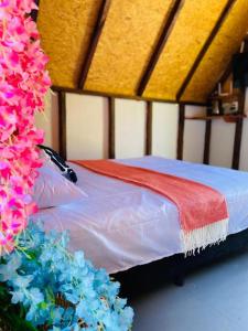 un letto con una coperta rossa e fiori blu di Hotel Cabañas Villa Loe Jardín a Jardin