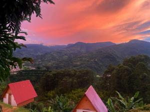 a sunset over a mountain range with houses and trees at Hotel Cabañas Villa Loe Jardín in Jardin