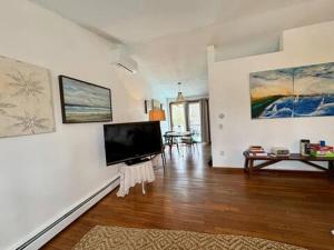 a living room with a flat screen tv on a wall at Room in a home in Narragansett