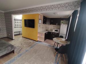 Una pequeña cocina con una pared amarilla y una mesa. en Квартира посуточно в Шахтинске, en Shakhtīnsk