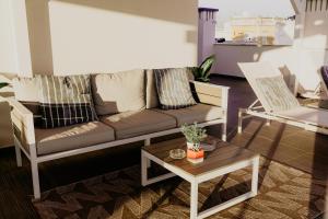 un soggiorno con un divano e un tavolo di Apartamentos Sol & Ria a Olhão