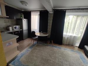 cocina con mesa pequeña y nevera en Квартира посуточно в Шахтинске, en Shakhtīnsk