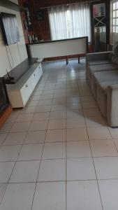 a living room with a white piano on a tiled floor at Chácara maria bonita in Rio Branco