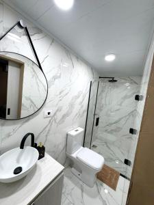 a bathroom with a toilet and a sink and a shower at Hotel SMA in Puerto Iguazú