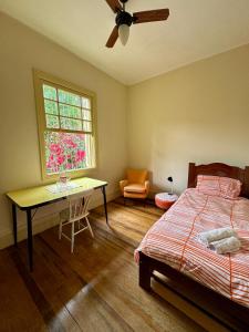 a bedroom with a bed and a desk and a window at Quarto aconchegante com vista arborizada, próximo ao metrô Ana Rosa e Avenida Paulista! in Sao Paulo