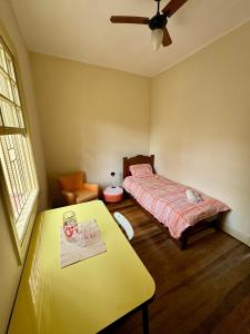 a bedroom with a bed and a table in it at Quarto aconchegante com vista arborizada, próximo ao metrô Ana Rosa e Avenida Paulista! in Sao Paulo