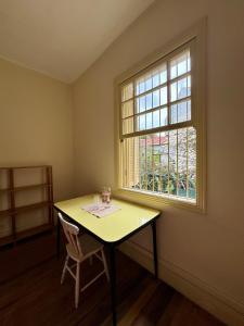 a yellow table and a window in a room at Quarto aconchegante com vista arborizada, próximo ao metrô Ana Rosa e Avenida Paulista! in Sao Paulo