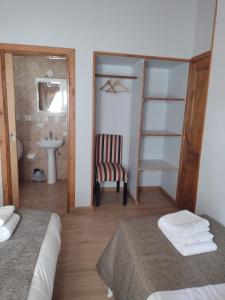 a room with two beds and a bathroom with a sink at La Cabaña de Juan in Villa Traful