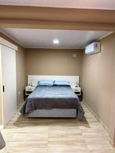 a bedroom with a bed and two night stands at Hotel SMA in Puerto Iguazú