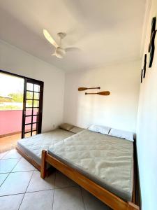 a bedroom with a bed and a ceiling fan at Apartamento à beira-mar Ilha Comprida in Ilha Comprida