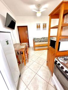 a kitchen and living room with a table and a refrigerator at Apartamento à beira-mar Ilha Comprida in Ilha Comprida