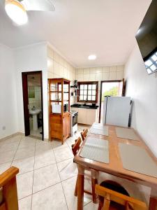 a kitchen and dining room with a table and a refrigerator at Apartamento à beira-mar Ilha Comprida in Ilha Comprida +11 photos