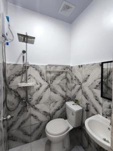a bathroom with a toilet and a sink at AMS Apartment in Butuan +17 photos