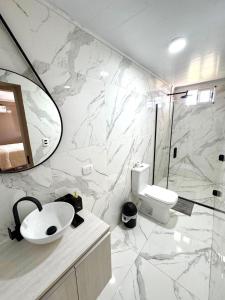 a bathroom with a sink and a toilet and a mirror at Hotel SMA in Puerto Iguazú