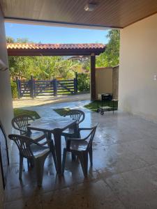 a patio with a table and chairs and a grill at Aconchego da Serra in Nova Friburgo
