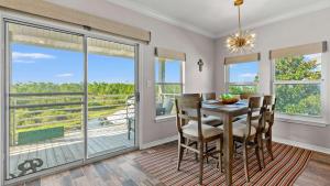a dining room with a table and chairs and a balcony at Cozy 3-Bedroom Condo - Comfy Living Space Two Balconies Outdoor Pool Beach Walkable - Score up to 450 Every Day in Tickets for Local Activities in Romar Beach