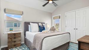 a bedroom with a bed with a stuffed animal on it at Cozy 3-Bedroom Condo - Comfy Living Space Two Balconies Outdoor Pool Beach Walkable - Score up to 450 Every Day in Tickets for Local Activities in Romar Beach +19 photos