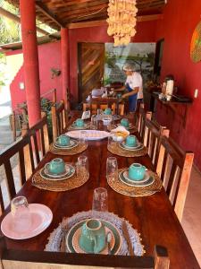 a long wooden table with plates and dishes on it at Point lanabarra in Amontada