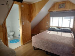 a bedroom with a bed with a window and a toilet at Departamento un solo ambiente in Valdivia +13 photos