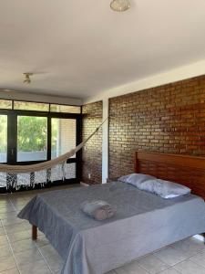 a bedroom with a bed and a brick wall at Casa de Campo in Eusébio +17 photos