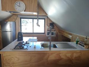 a kitchen with a sink and a clock on the wall at Departamento un solo ambiente in Valdivia
