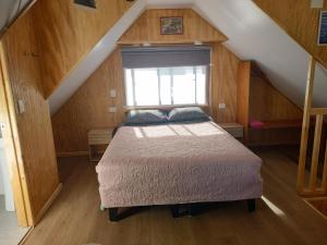 a bedroom with a bed in a attic at Departamento un solo ambiente in Valdivia