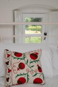 a pillow sitting on a bed in front of a window at The Triumphal Arch East in Holkham