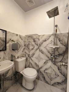 a bathroom with a toilet and a sink at AMS Apartment in Butuan