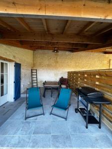a patio with two blue chairs and a table at Gîte Le Ptit Poirier in Coulon
