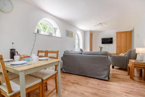 a living room with a couch and a table at Vine Cottage in West Runton