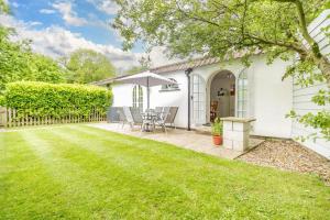 a white house with a lawn in front of it at Vine Cottage in West Runton