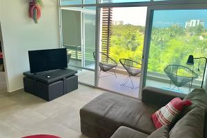 ein Wohnzimmer mit Couch und Flachbildfernseher in der Unterkunft 506 Plaza 3.14 by Del Mar in Nuevo Vallarta