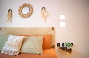 ein Schlafzimmer mit einem orangefarbenen Bett mit einem Spiegel an der Wand in der Unterkunft Kaíoro Tulum in Tulum