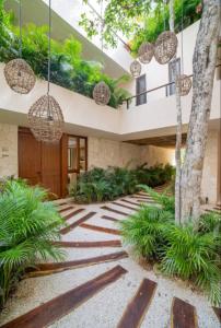 ein Innenhof mit Pflanzen und Kronleuchtern in einem Haus in der Unterkunft Kaíoro Tulum in Tulum