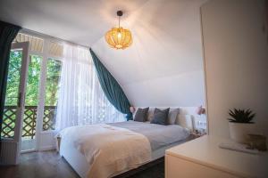 a bedroom with a bed and a window at Keszeg44 Vendégház in Tiszakécske