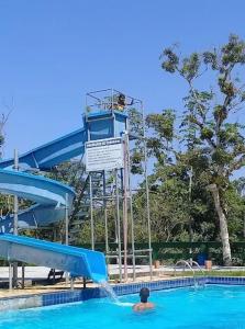 een man in een zwembad met een glijbaan bij Pousada e Pesqueiro Belo Vale in Juquiá