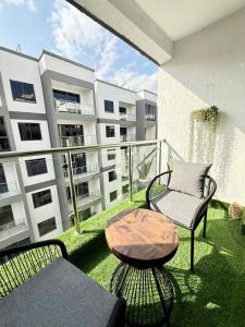 a balcony with a chair and a table and a building at Oderms cozy apartment with Gym and Swimming Pool in Nairobi near JKIA Airport & SGR in Nairobi