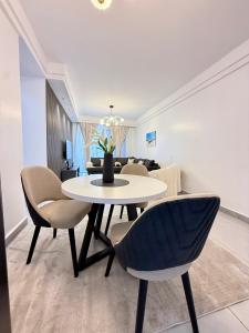 a dining room and living room with a table and chairs at Oderms cozy apartment with Gym and Swimming Pool in Nairobi near JKIA Airport & SGR in Nairobi