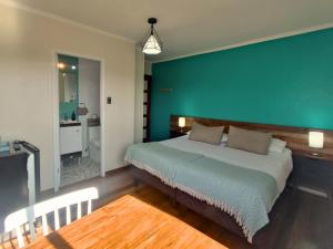 a bedroom with a bed with a green wall at Hostal Terraza Recreo in Viña del Mar