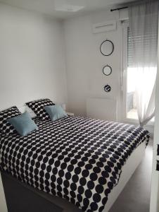 a black and white bed in a room with a window at Charmant appartement 2 chambres - Proche Tours in Joue-les-Tours