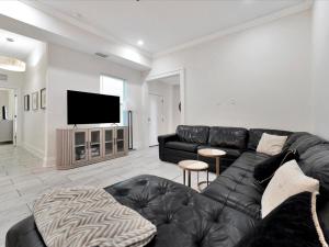 a living room with a black leather couch and a flat screen tv at Walking Distance to Downtown Free Parking in Tampa