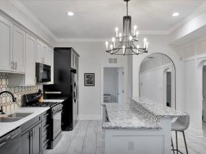 a kitchen with white cabinets and a black and white counter top at Walking Distance to Downtown Free Parking in Tampa +12 photos