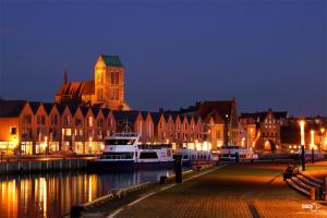 a city at night with boats in the water at Urlaub im Herzen Wismars 2OG Süd in Wismar +13 photos