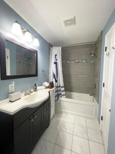 Un baño con lavabo, bañera y ducha. en Myrtle's Paradise - 2 BR, 1 BA, Step to Crystal Beach, en Fort Erie