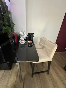 a table with a white chair and a black table at Loft 11 personnes Sauna Jacuzzi in Mouscron