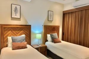 a bedroom with two beds and a lamp on a table at D'Toscana 308 by Del Mar in Nuevo Vallarta  +14 photos
