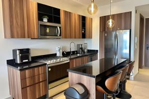 a kitchen with black counter tops and wooden cabinets at D'Toscana 308 by Del Mar in Nuevo Vallarta 