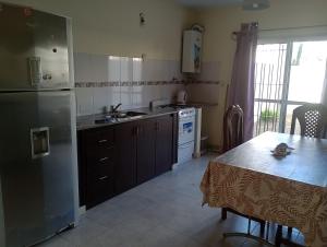 a kitchen with a refrigerator and a table in it at Duplex Rawson in Gualeguaychú