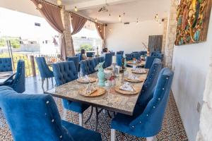 a dining room with a table and blue chairs at Hotel Villa Peñasco in Bernal