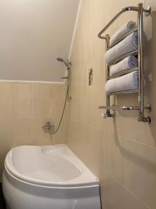 a bathroom with a toilet and towels on a wall at S'Vitt in Skhidnitsa +109 photos